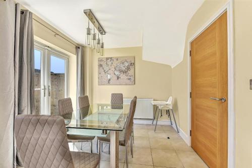 a dining room with a glass table and chairs at London Heathrow Living Holywell Serviced Houses - 3 and 4 bedrooms By Ferndale in Stanwell