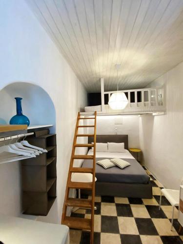 a small bedroom with a bunk bed and a ladder at Bougainvillea Friends & Family Studio - Old Town in Mikonos