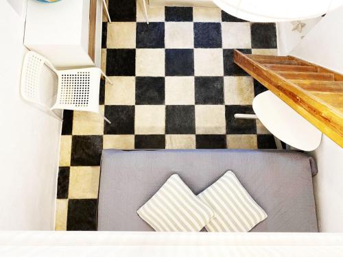 a chair with two pillows on a checkered floor at Bougainvillea Friends & Family Studio - Old Town in Mýkonos City