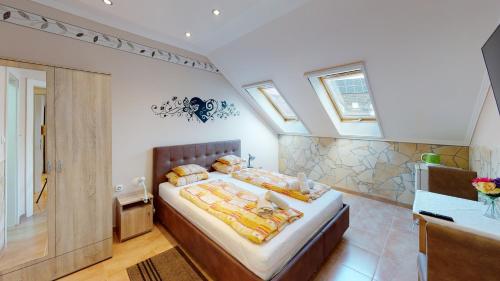 a bedroom with a large bed in a attic at Cristian Apartman in Hajdúszoboszló