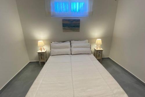 uma cama num quarto com duas lâmpadas de cada lado em Karavias cosy Vlicho house em Vlikhón
