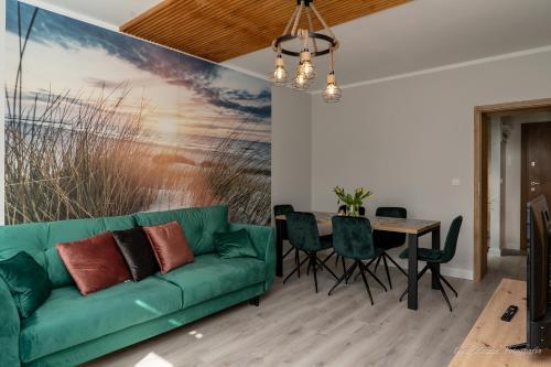 a living room with a green couch and a table at Aquarius Baltico Apartment in Ustka