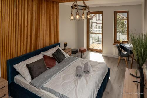 a bedroom with a bed with shoes on it at Aquarius Baltico Apartment in Ustka
