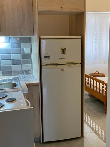 a white refrigerator in a kitchen next to a stove at Karavias Vlicho studio in Vlikhón
