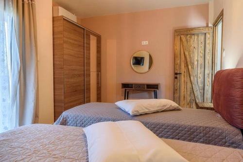 a bedroom with two beds and a mirror and a door at Melina's cosy appartment in Argalasti