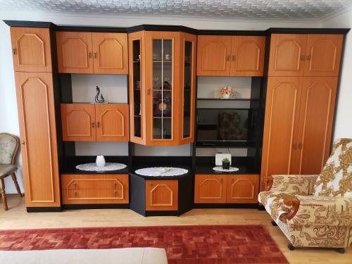 ein Wohnzimmer mit Holzschränken und einem Sofa in der Unterkunft Aida apartman in Harkány