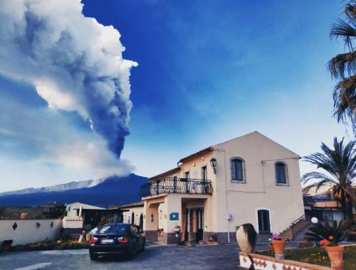 a plume of smoke behind a building with a car at Villa Laura Apartment in Giardini Naxos