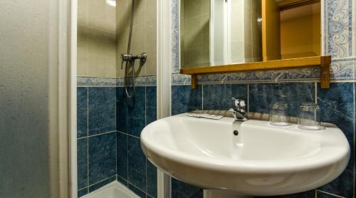 a bathroom with a white sink and a mirror at Hotel Valdemoro in Valdemoro