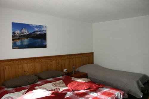 una camera con un letto e una foto appesa al muro di Furggen a Valtournenche