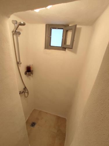 a bathroom with a shower and a window at Bougainvillea Friends & Family Studio - Old Town in Mikonos
