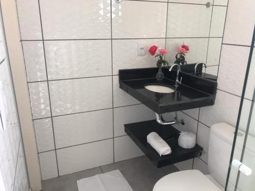 a bathroom with a sink and a toilet at Pousada Morada dos Pássaros in Capitólio
