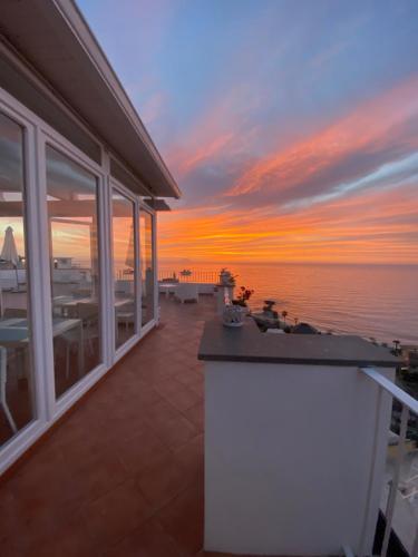 a balcony with a view of the ocean at sunset at Tropea Boutique Hotel in Tropea