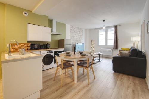 Il dispose d'une cuisine et d'un salon avec une table et un canapé. dans l'établissement La Balade Nîmoise Center Car Park AC, à Nîmes