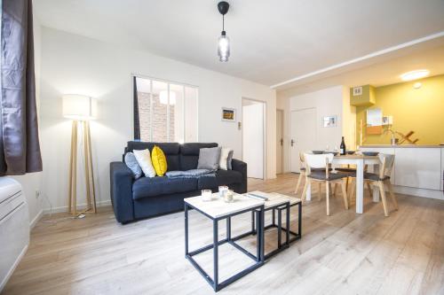 a living room with a blue couch and a table at La Balade Nîmoise Center Car Park AC in Nîmes