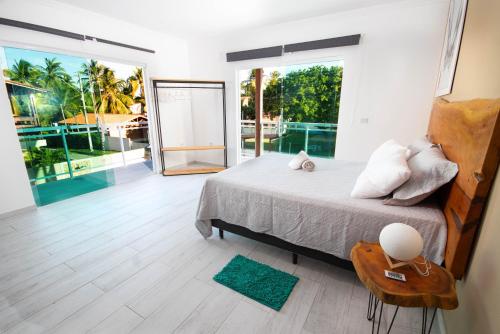 a bedroom with a bed and a large window at Casas Peroba Maragogi in Maragogi