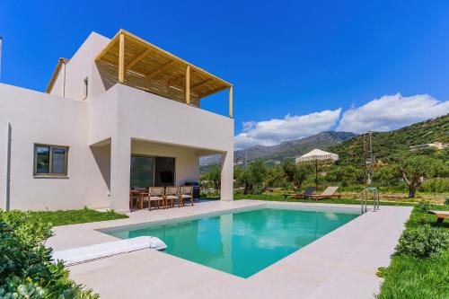 a villa with a swimming pool and a house at Increteblue Suites in Plakias