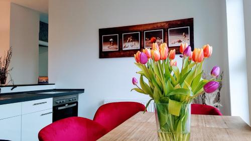 a vase of tulips on a table in a kitchen at Villa Appartements Syke in Syke