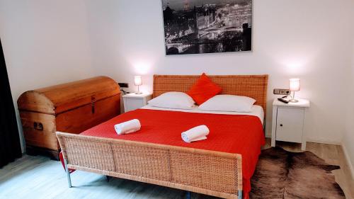 a bedroom with a red bed with two pillows on it at Villa Appartements Syke in Syke