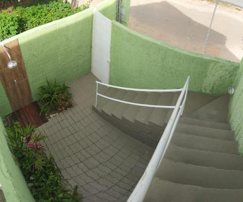 a set of stairs next to a green wall at Chalés Aconchego in Cavalcante