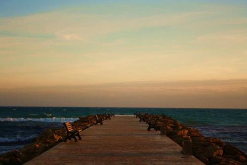 a pier with a row of benches on the beach at Il terrazzo dei templi in Marinella di Selinunte