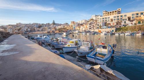 a group of boats docked in a harbor with buildings at Il terrazzo dei templi in Marinella di Selinunte