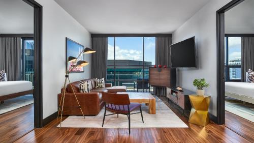 a living room with a couch and a tv at The Rally Hotel at McGregor Square in Denver