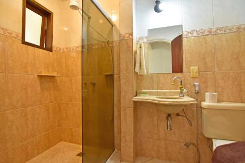 a bathroom with a shower and a sink and a toilet at Hotel Velejador,há 5 minutos do Centro Historico in Paraty