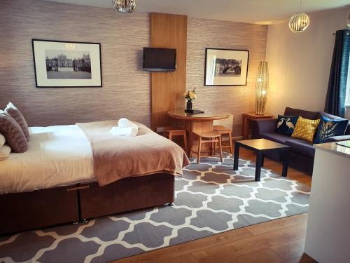a hotel room with a bed and a couch and a table at The Churchill Court in Woodstock