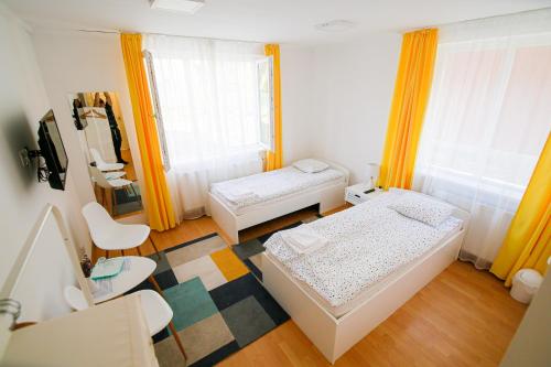 a small room with two beds and a table at Capra Vecinului in Târgu-Mureş
