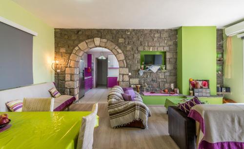 een woonkamer met groene en paarse muren bij Stone House Yiota in Plaka Milou