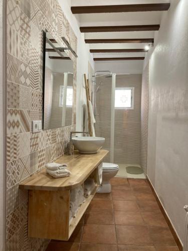 Un baño con lavabo, inodoro y espejo. en Cal Pere de L'Onclet, en Montblanc