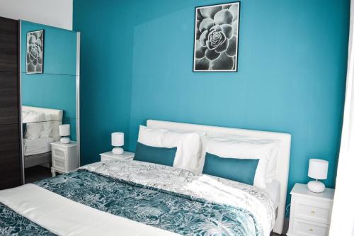 a blue bedroom with a bed with a blue wall at Le Blue St Léon : 2 pièces COZY Lit King Size WIFI in Colmar
