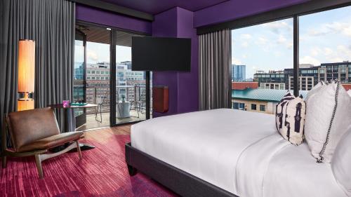 a bedroom with a large bed and a large window at The Rally Hotel at McGregor Square in Denver