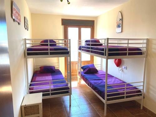 アヤモンテにあるCosta Esuri Golf y Playa IIIの紫色のベッドが備わる客室の二段ベッド2台