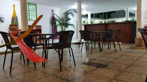 a table and chairs with umbrellas in a room at Hotel El Don in Pueblo Bello
