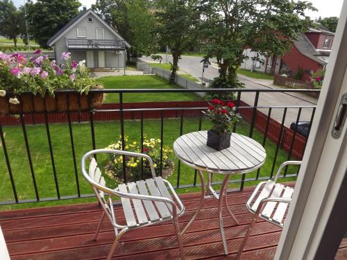 a balcony with two chairs and a table with flowers at Suur-Sadama Apartment in Kuressaare