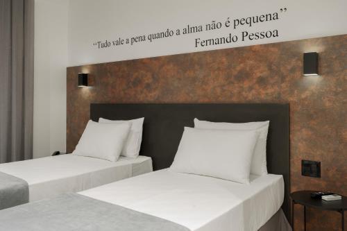 2 camas con almohadas blancas en una habitación de hotel en Slaviero Chapecó, en Chapecó