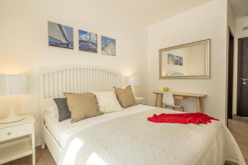 a bedroom with a white bed with a red shirt on it at B&BLeucaineout in Leuca
