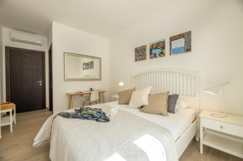 a bedroom with a large white bed and a desk at B&BLeucaineout in Leuca