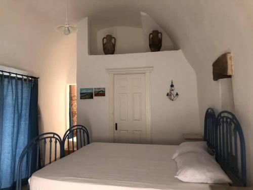 a bedroom with a bed and a door and a window at Casetta delle anfore in Alliste