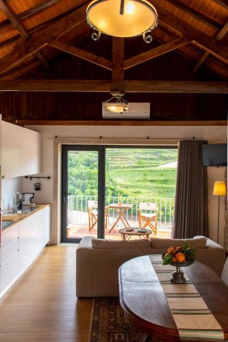 a living room with a table and a kitchen with a view at Quinta do Tapadinho - Wine & Tourism in Moimenta