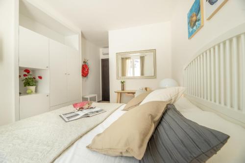 a white bedroom with a large bed and a stair case at B&BLeucaineout in Leuca