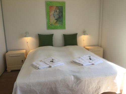 una camera da letto con un letto bianco e asciugamani di Ferielejligheder i centrum af smukke Ebeltoft a Ebeltoft