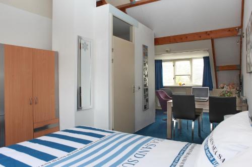 1 dormitorio con 1 cama, mesa y sillas en Teska Bed & Breakfast en Veenendaal