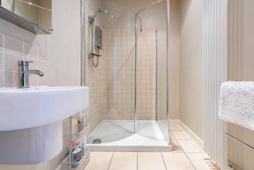 a bathroom with a shower and a sink at Milton Bank Mansion Garden Apartment in Broughty Ferry
