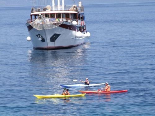 a group of people in kayaks in the water with a large boat at Apartments Dijana - 20m from the sea in Prigradica
