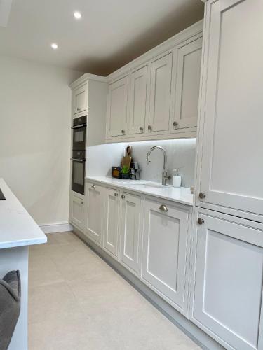 a white kitchen with white cabinets and a sink at Edge Mere Apartment, Bowness-on-Windermere in Bowness-on-Windermere