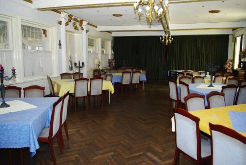 uma sala de jantar com mesas e cadeiras e um lustre em Pension Genengerhof em Viersen