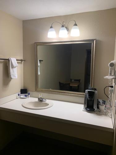 a bathroom with a mirror and a sink at Sunset Inn - John Day in John Day