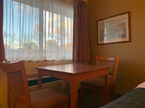 a room with a table and chairs and a window at Sunset Inn - John Day in John Day